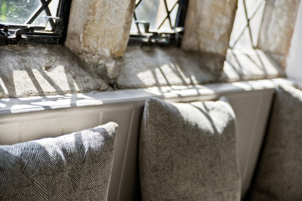 Cushions in the old hall with mullioned windows